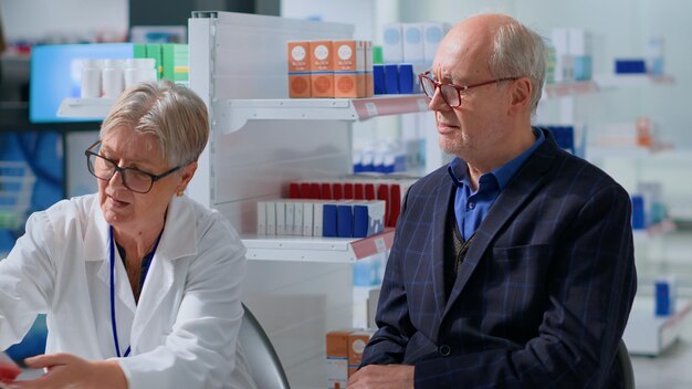 Foto exame de farmacêutico e de doentes idosos