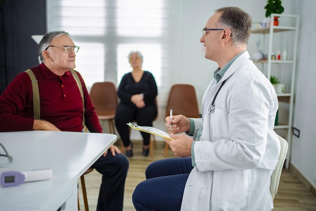 Exame de saúde de homens idosos num escritório médico moderno