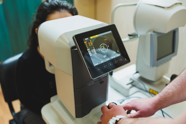 Exame de visão em equipamentos oftalmológicos modernos Exame oftalmológico de uma mulher em uma consulta oftalmológica usando microscópios Tratamento da visão em uma consulta oftalmológica