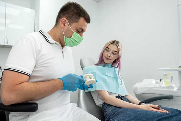 Examen de un dentista que trata a una paciente que acudió a él con quejas Una mujer tiene un examen dental programado en el dentista