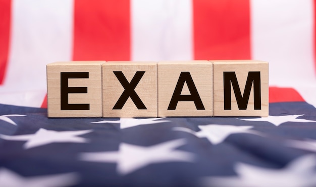 Examen de la palabra en cubos de madera en la bandera americana.