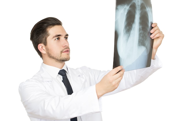 Examinando com cuidado. retrato de estúdio de meio comprimento de um médico examinando uma radiografia do paciente