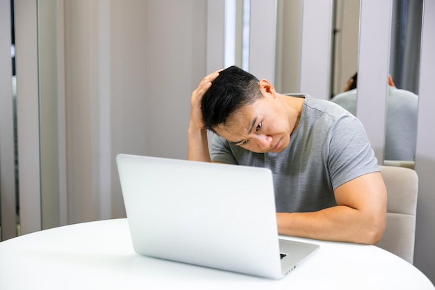 Exausto freelancer masculino sobrecarregado com laptop sentindo-se mal, tontura, tensão ocular, dor, dor de cabeça