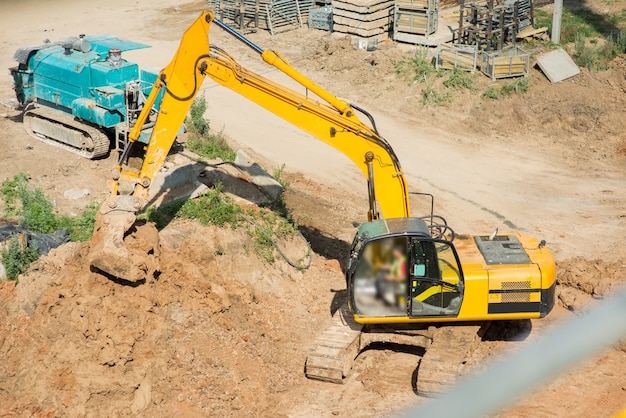 Excavadora amarilla excava el suelo en un sitio en construcción