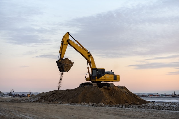 Excavadora amarilla trabajando en obra. La construcción de carreteras.