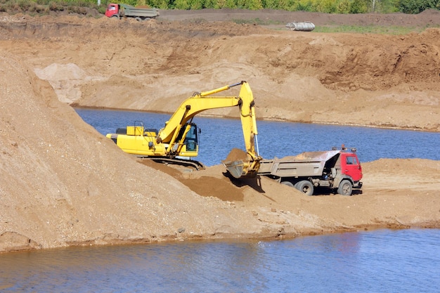 Excavadora de arenero y volquete