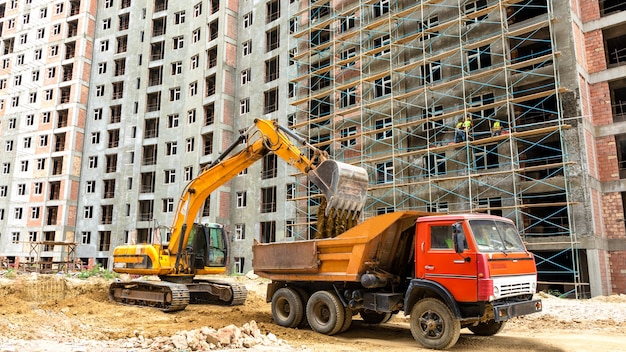 Excavadora y cabina sobre camión en el sitio de construcción