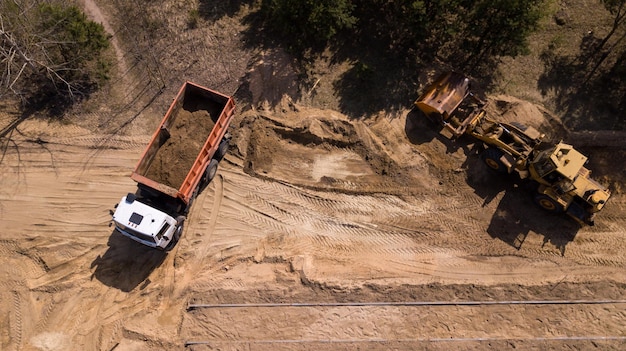 Excavadora cargando arena en un camión con drone de fotografía aérea