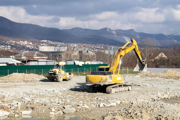 Una excavadora de construcción despeja un sitio de construcción para la fundación de un futuro hogar