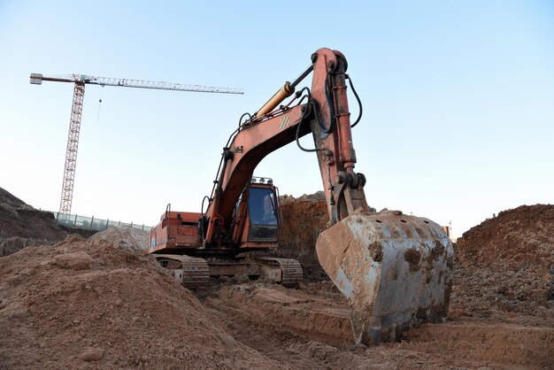 Foto excavadora durante o movimento de terra no local de construção