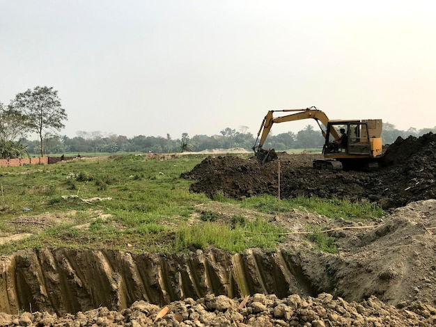 Una excavadora está cavando un hoyo en un campo.