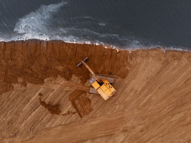 Excavadora maquinando un movimiento de tierra en la orillaFotografía aéreaVista superior