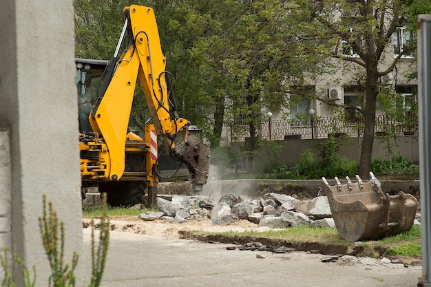 Foto excavadora con martillo hidráulico rompe un pilote de hormigón en un sitio en construcción