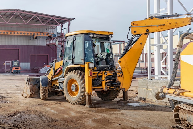 Una excavadora o cargadora ayuda en la producción de trabajos monolíticos de hormigón armado en un sitio de construcción. Uso de equipo de construcción.