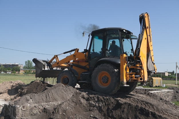 Excavadora y obra nueva en campo.