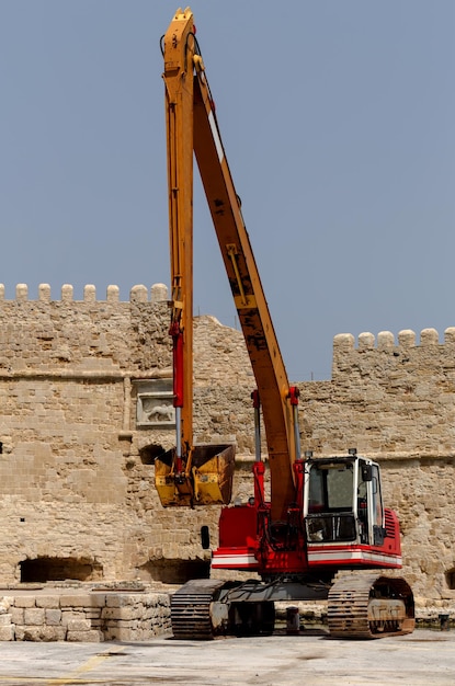 Excavadora de oruga roja grande con primer plano de cubo amarillo grande