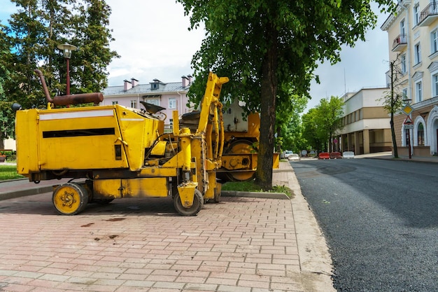 Foto una excavadora y otros equipos de construcción pesados están trabajando en el sitio de construcción trabajos viarios de colocación de nuevo asfalto en la ciudad