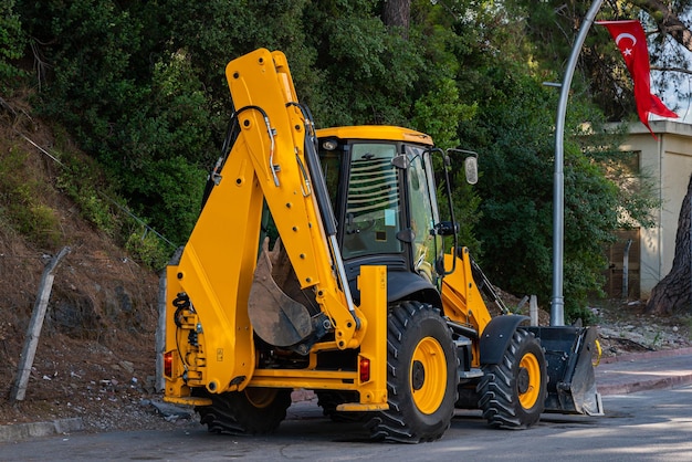 Excavadora de ruedas amarilla de pie al lado de la carretera