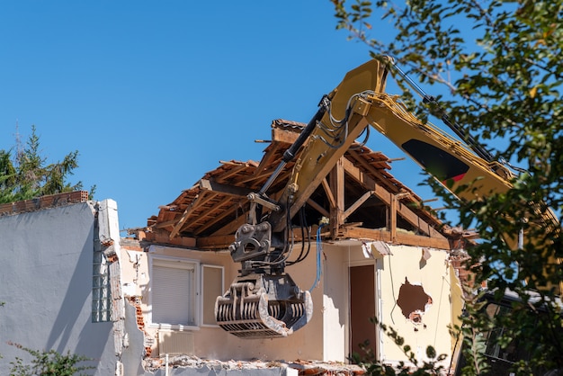 Excavadora del sitio de construcción casa de demolición amarilla para reconstrucción