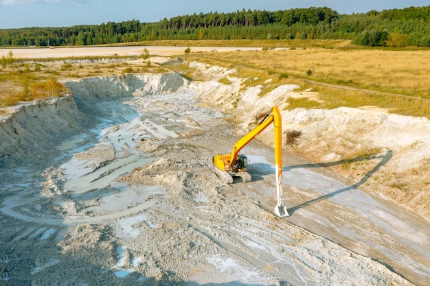 Una excavadora en un sitio de construcción planifica el terreno antes de trabajar en los cimientos