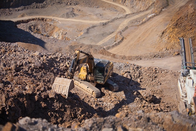 Excavadora trabajando en cantera de minería excavadora pesada amarilla grande moviendo piedra en una cantera