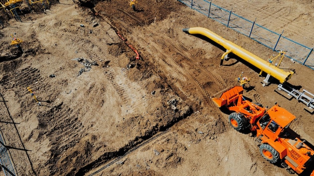 Excavadora de vista aérea y trabajadores de la construcción que trabajan en el sitio de construcción en campo abierto Colocación de tuberías en zanjas para gasificación Punto superior de disparo Reparación y restauración del suministro de gas natural