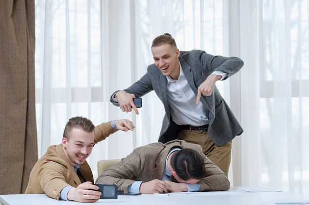 Exceso de trabajo estrés risa compañero de trabajo cansado burlándose