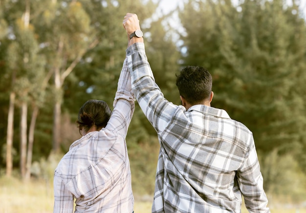 Foto excursiones de éxito y espalda de una pareja tomándose de la mano en el bosque para lograr la victoria o los objetivos de fitness libertad de viaje y hombre con mujer celebrando un viaje histórico y un objetivo de aventura en la naturaleza