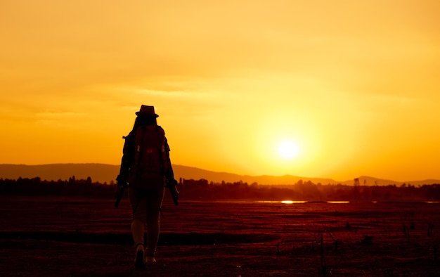 Foto un excursionista caminando por el paisaje contra el cielo durante la puesta de sol