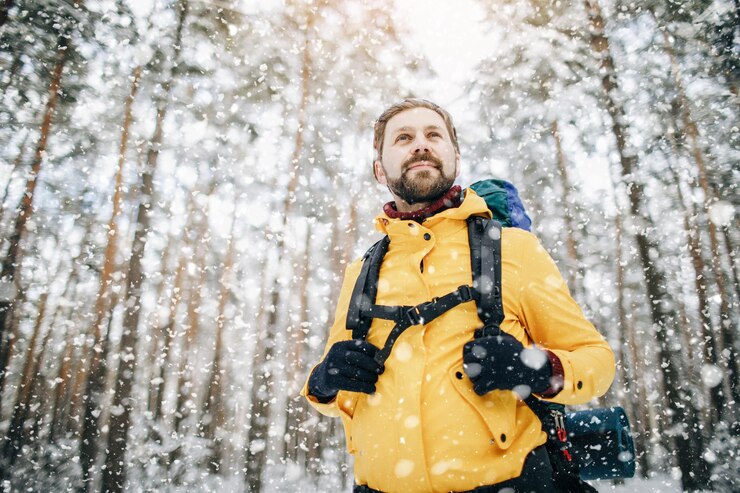 Excursionista entusiasta estimando su ruta adicional a través del bosque de invierno