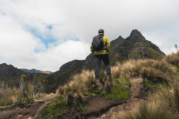 Excursionista de hombre con mochila frente a una montaña