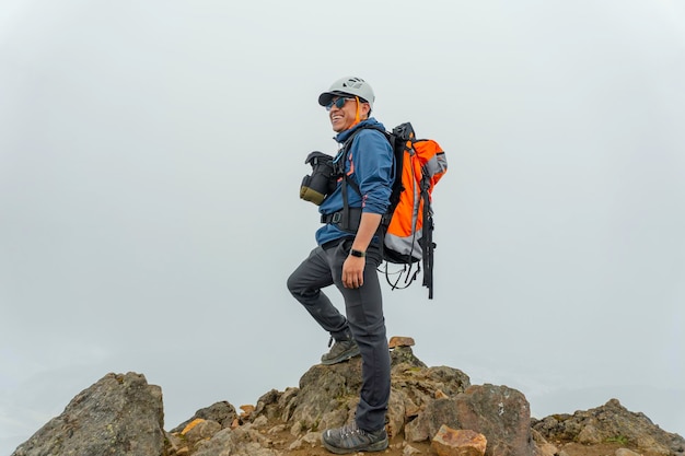 Excursionista de hombre con mochila frente a una montaña