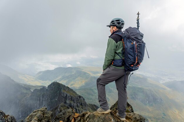 Excursionista de hombre con mochila frente a una montaña