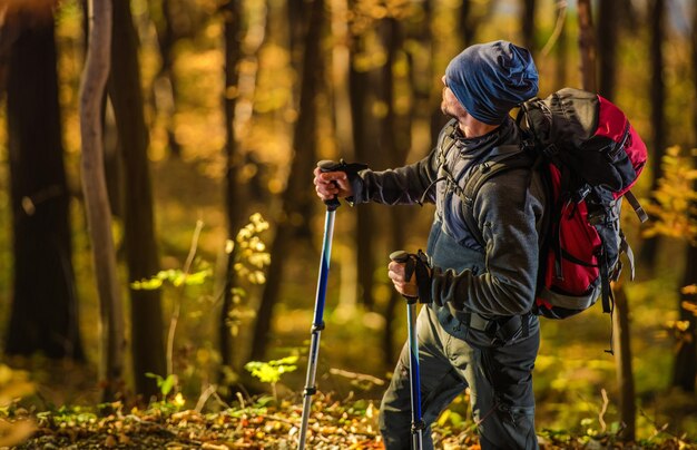 Foto un excursionista masculino haciendo senderismo en el bosque durante el otoño