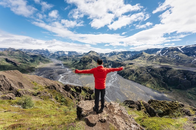 Excursionista masculino de pie con alegría en la cima de la montaña en el mirador de Valahnukur