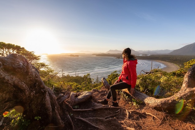 Excursionista mujer aventurera con vistas a la playa de arena en la costa oeste del océano Pacífico