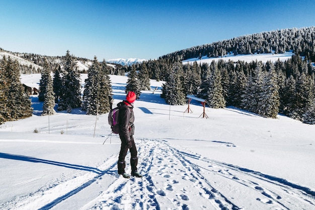 Excursionista de mujer caminando sobre la nieve en el país de invierno