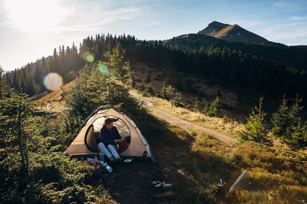 Foto excursionista de mujer en carpa en montañas