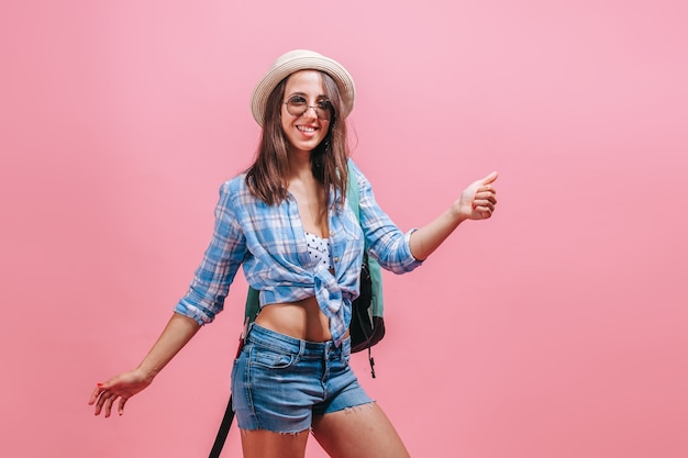 Foto excursionista mujer coge un paseo en una pared rosa