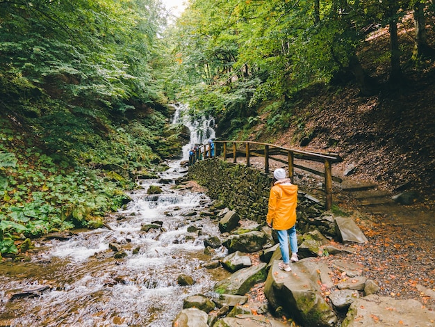 Foto excursionista de mujer mirando el espacio de copia de cascada de los cárpatos