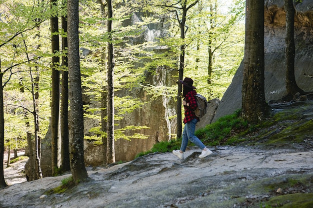 Excursionista de mujer con mochila caminando por espacio de copia de sendero forestal