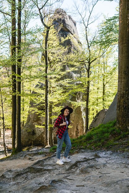 Excursionista de mujer con mochila caminando por pista forestal