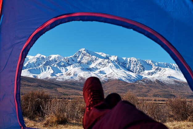 Excursionista relajante disfrutando de la vista desde la tienda de acampar entrada al aire libre. Viajes estilo de vida concepto aventura vacaciones al aire libre.