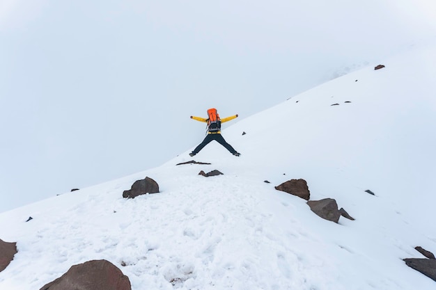 Un excursionista saltando en la base de la montaña chimborazo en ecuador