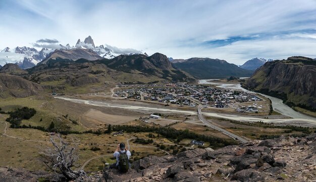 Foto un excursionista con vistas a una pintoresca ciudad montañosa en la patagonia