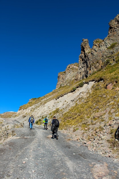 Los excursionistas caminan por el sendero alrededor de las rocas de granito y las montañas en la región del Monte Elbrus, el pico más alto de Rusia y Europa.