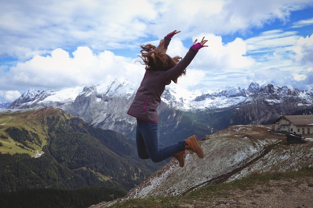 Excursionistas chica saltando en las montañas Dolomitas, Italia.