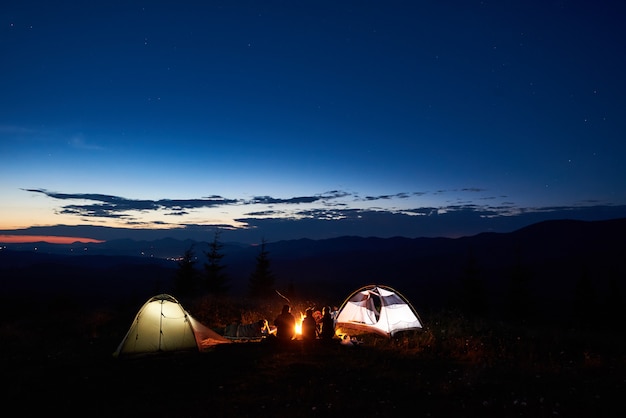 Excursionistas familiares que descansan por la noche acampando en las montañas