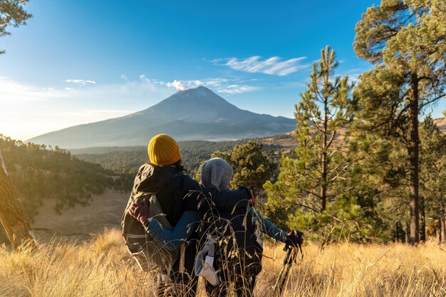 Excursionistas felices con el volcán popocatepetl al fondo