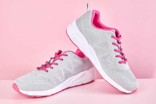 Executando sapatos esportivos em fundo rosa, par de tênis elegantes da moda